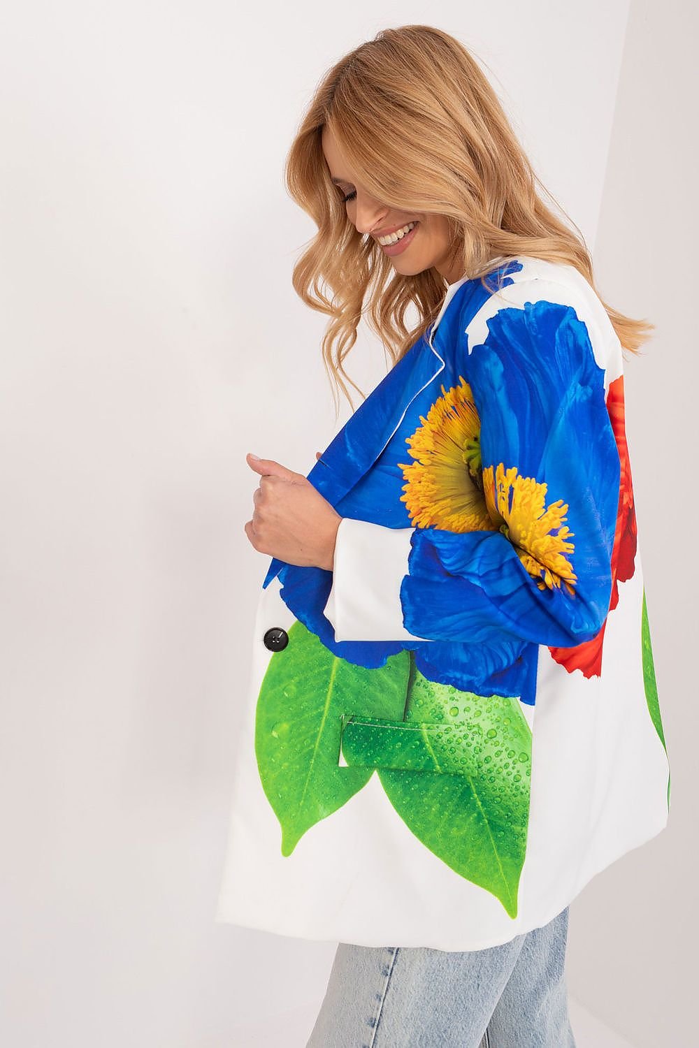 Rechter aanzicht van een witte blazer met een opvallende grote bloemenprint in rood, blauw en groen, gedragen door een vrouw met jeans.