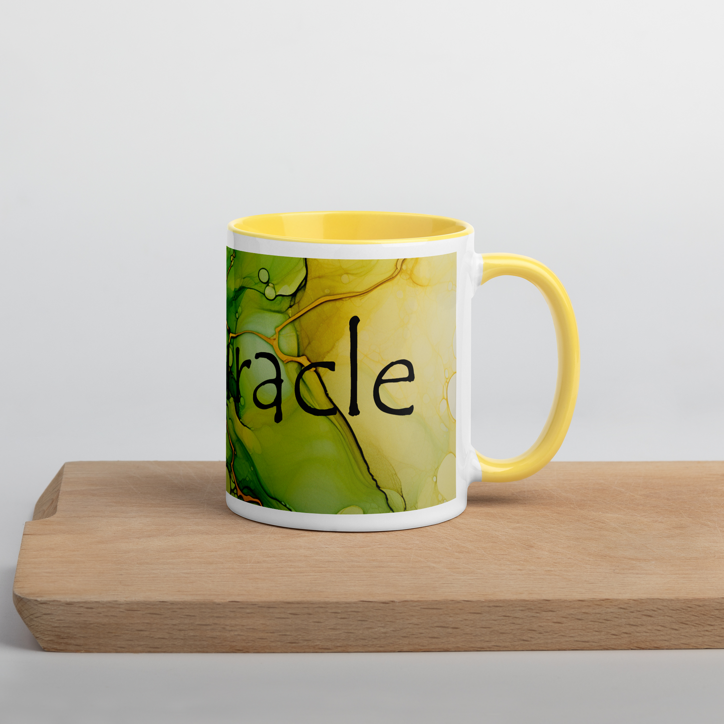 Een witte keramische koffiemok met een all-over afbeelding van Alcohol Ink Print, Big Miracle, vooraanzicht, 11 oz, met een gele binnenkant, op een witte achtergrond. Het handvat staat recht vooruit en de mok staat op een snijplank