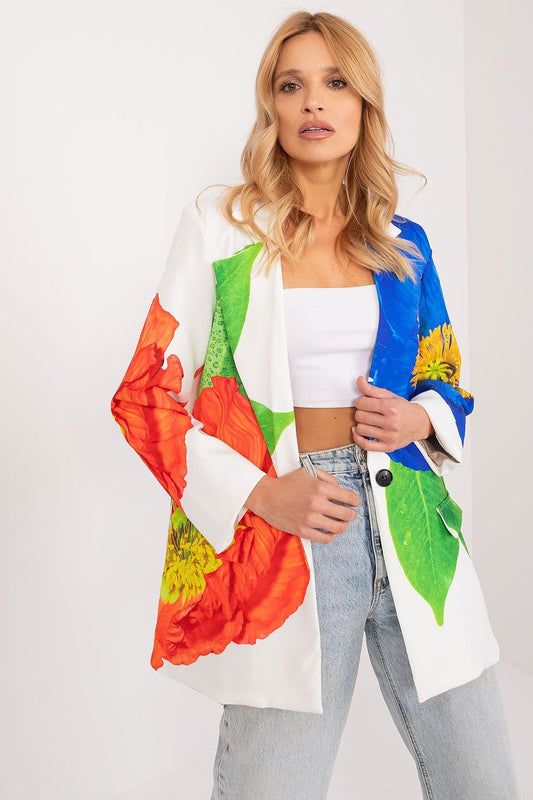 Vrouw draagt een witte blazer met grote, kleurrijke bloemenprint, gecombineerd met een witte crop top en jeans. voorzicht