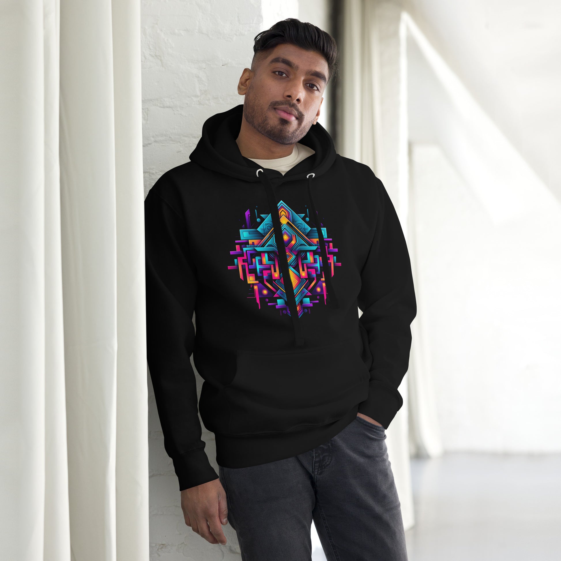 Een zwart unisex premium hoodie met een geometrische afbeelding, gedragen door een man, vooraanzicht, met een gordijn als achtergrond