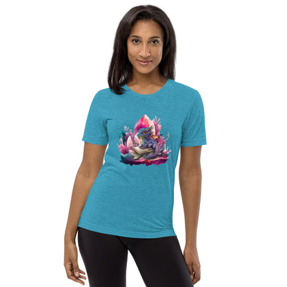  Een aqua  triblend unisex T-shirt met een afbeelding van een kleine draak en een magisch boek, gedragen door een blije vrouw, op een witte achtergrond. De vrouw staat naar voren gericht.